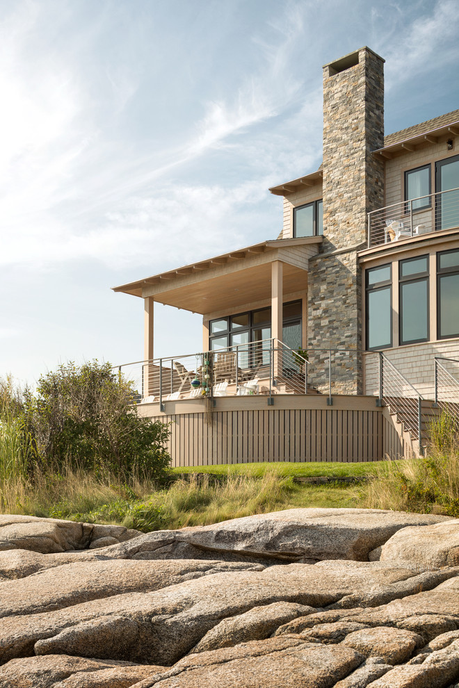 This is an example of a beach style two-storey beige exterior in Portland Maine with wood siding.