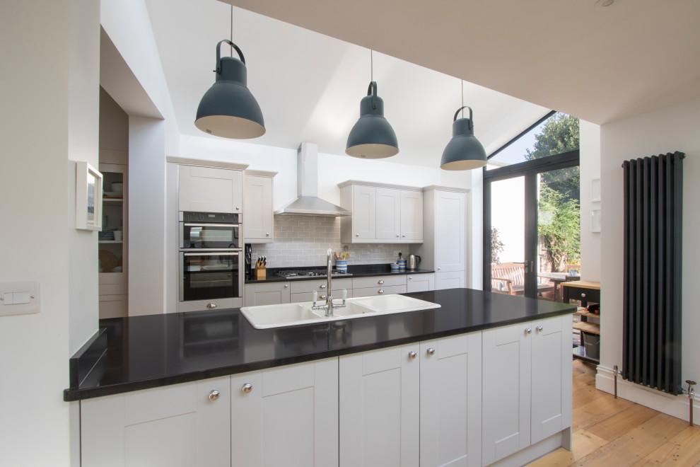 Photo of a modern galley open plan kitchen in Other with granite benchtops and ceramic splashback.