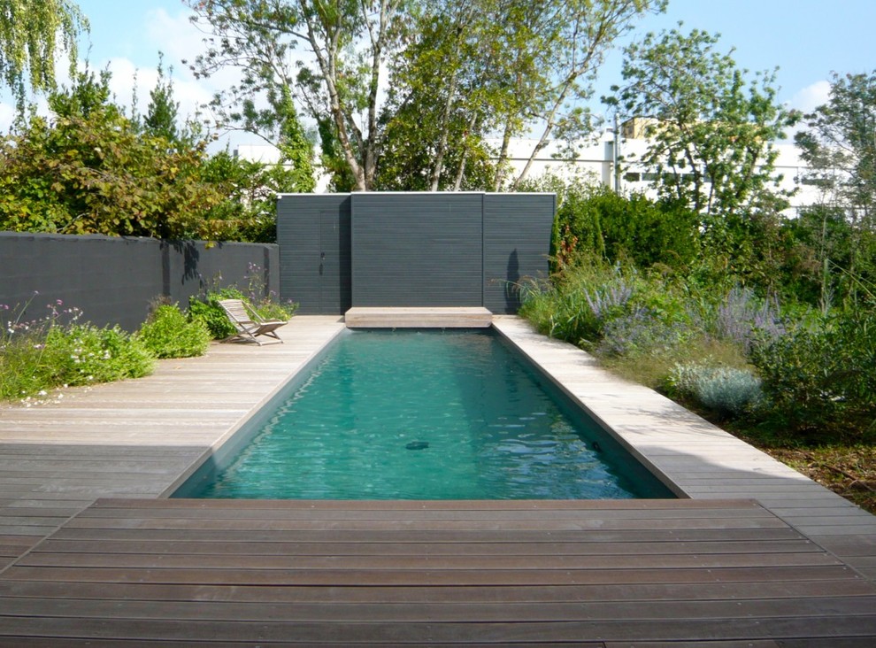 Design ideas for a mid-sized contemporary rectangular lap pool in Other with decking.