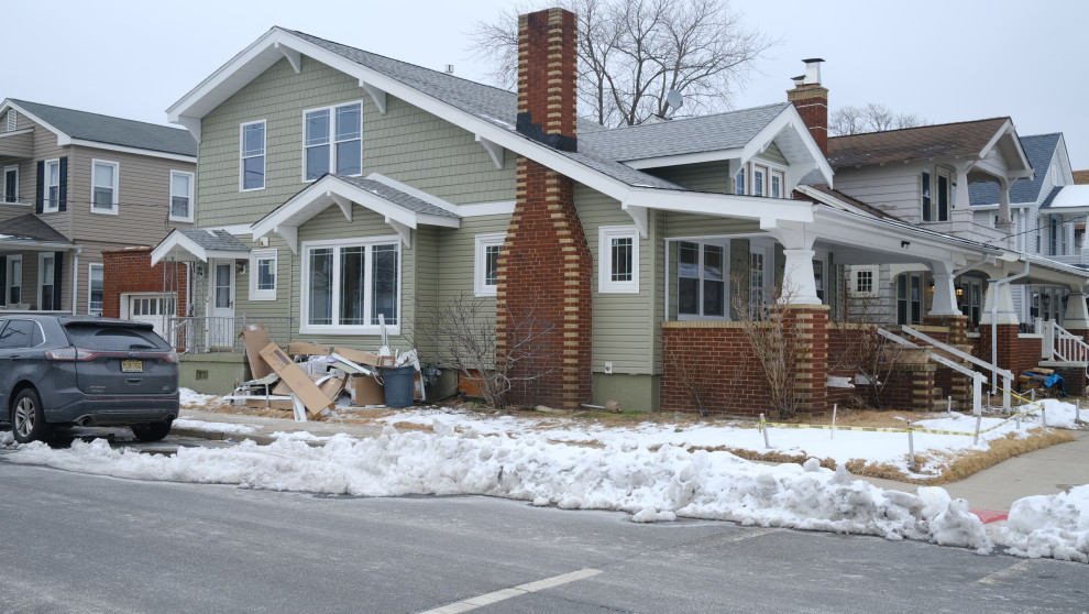 Kleines, Zweistöckiges Uriges Tiny House mit Vinylfassade, grüner Fassadenfarbe, Satteldach, Schindeldach, grauem Dach und Verschalung in New York