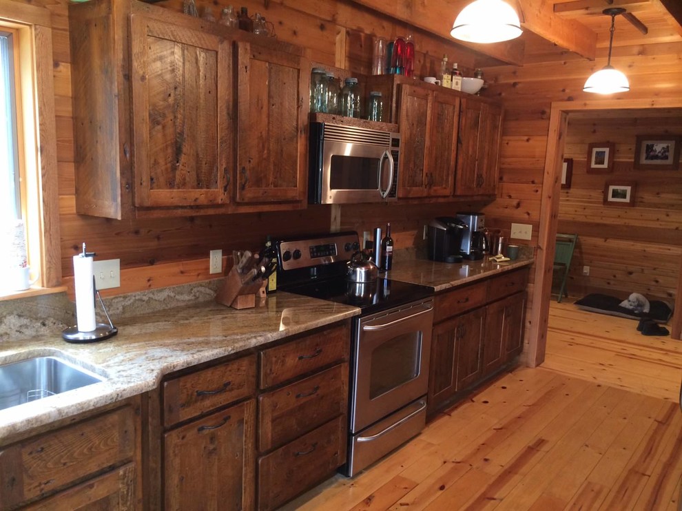 Eat-in kitchen - large rustic single-wall light wood floor and beige floor eat-in kitchen idea with an undermount sink, recessed-panel cabinets, dark wood cabinets, granite countertops, brown backsplash, wood backsplash, stainless steel appliances and no island