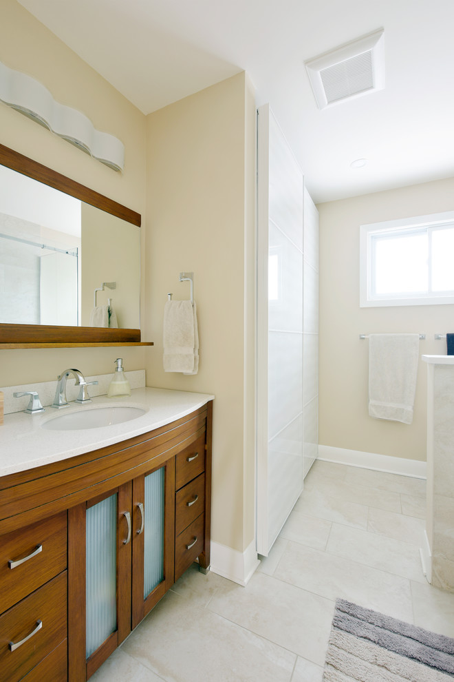 Mid-sized contemporary master bathroom in Ottawa with furniture-like cabinets, brown cabinets, a shower/bathtub combo, beige tile, a one-piece toilet, beige walls, an undermount sink, white floor, a sliding shower screen, solid surface benchtops, porcelain tile, a corner tub and porcelain floors.