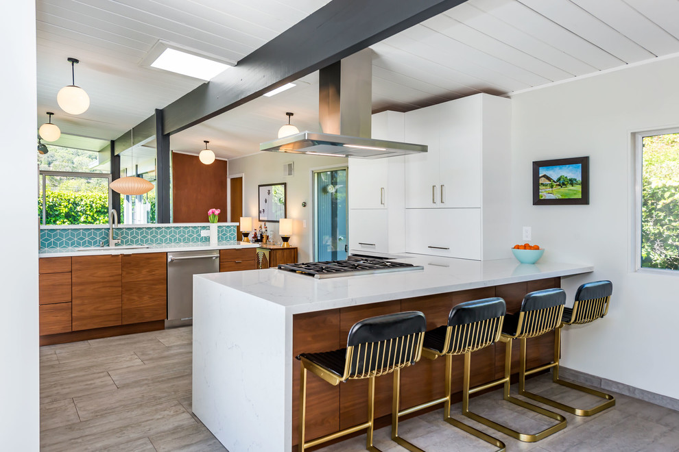 Photo of a mid-sized midcentury single-wall open plan kitchen in San Francisco with a drop-in sink, flat-panel cabinets, white cabinets, quartzite benchtops, blue splashback, ceramic splashback, stainless steel appliances, painted wood floors, a peninsula, grey floor and white benchtop.