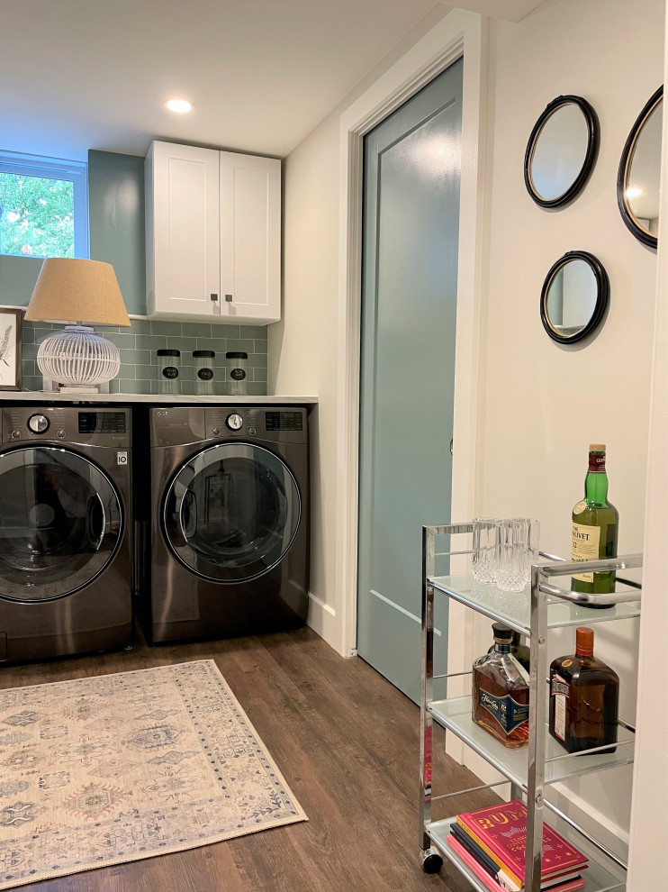 Inspiration for a mid-sized transitional vinyl floor and brown floor dedicated laundry room remodel in Montreal with a drop-in sink, shaker cabinets, white cabinets, laminate countertops, green backsplash, porcelain backsplash, beige walls, a side-by-side washer/dryer and white countertops