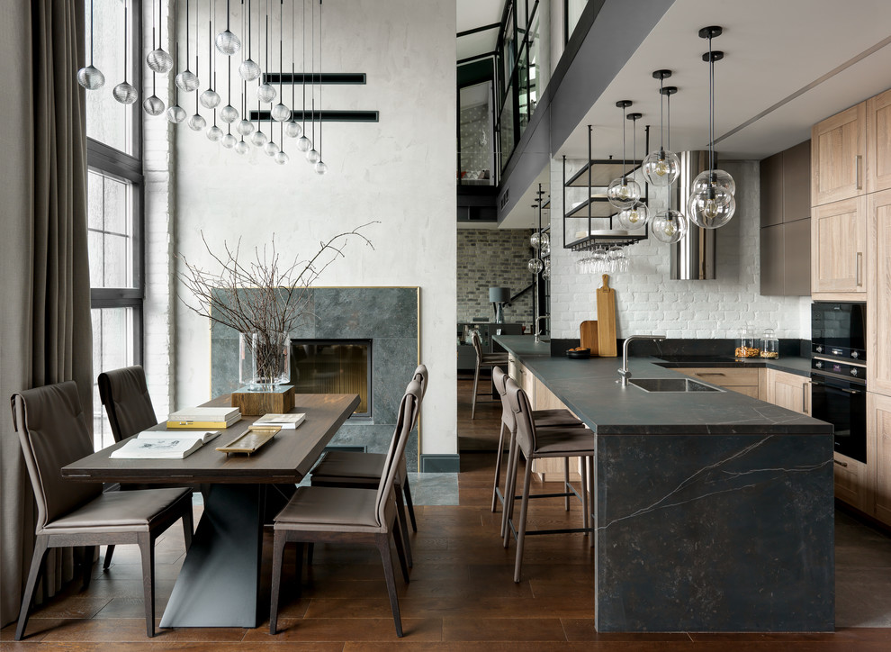 Design ideas for an industrial u-shaped open plan kitchen in Moscow with an undermount sink, recessed-panel cabinets, light wood cabinets, with island and black benchtop.