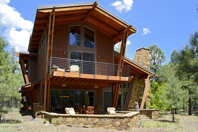 Balcony - mid-sized rustic two-story mixed siding multicolored balcony idea with a metal roof and a roof extension