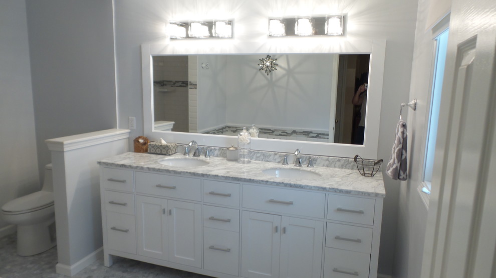 Photo of a large transitional master bathroom in Cleveland with shaker cabinets, white cabinets, an alcove shower, a one-piece toilet, gray tile, marble, grey walls, marble floors, an undermount sink, marble benchtops and grey floor.