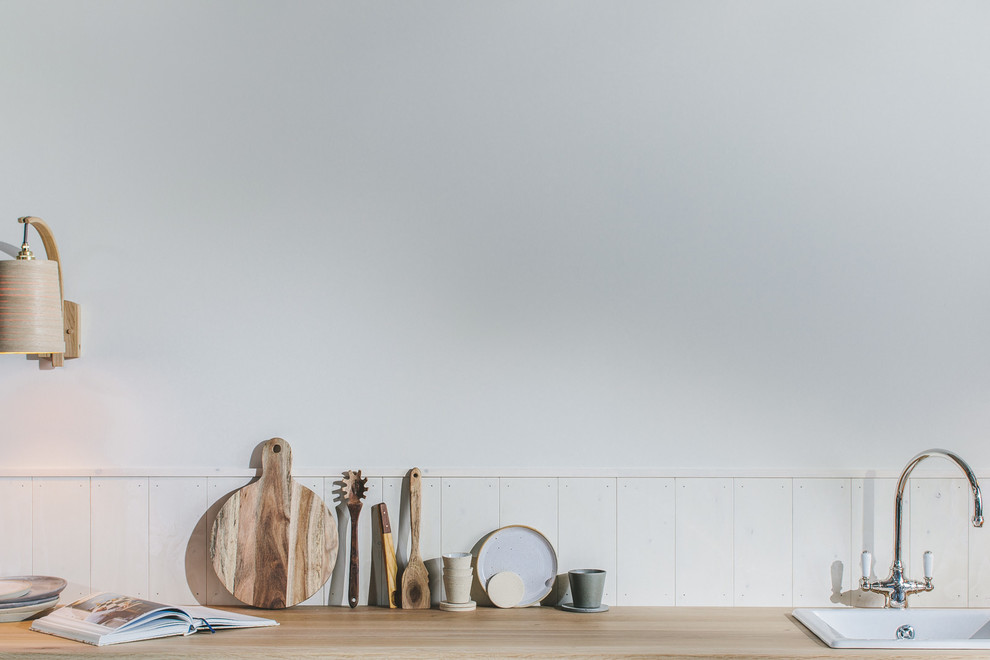 Inspiration for a small scandi single-wall open plan kitchen with a single-bowl sink, flat-panel cabinets, grey cabinets, wood worktops, white splashback, wood splashback, integrated appliances, painted wood flooring, no island, black floors and brown worktops.