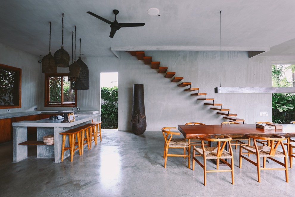 Inspiration for a tropical open plan dining in Singapore with grey walls, concrete floors and grey floor.