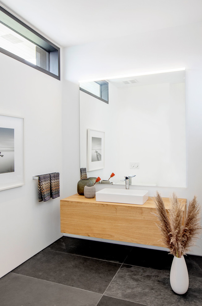 Large contemporary powder room in Vancouver with flat-panel cabinets, light wood cabinets, white walls, slate floors, a vessel sink, wood benchtops and multi-coloured floor.