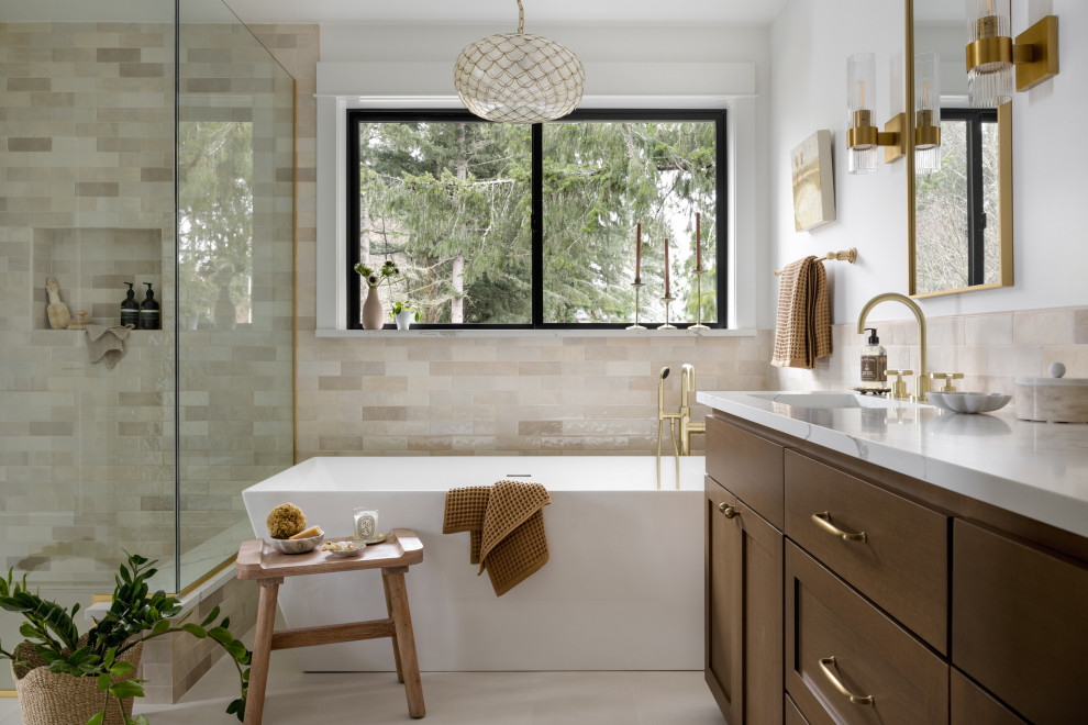 Large transitional master beige tile and ceramic tile porcelain tile, beige floor and double-sink freestanding bathtub photo in Seattle with shaker cabinets, brown cabinets, a one-piece toilet, white walls, an undermount sink, quartz countertops, a hinged shower door, white countertops and a built-in vanity