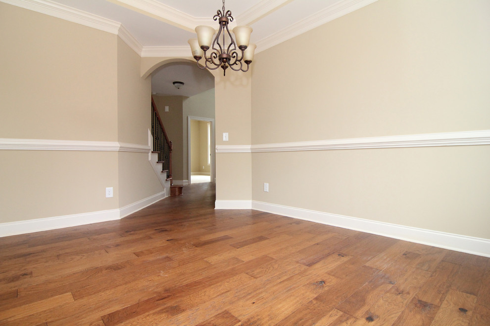 Photo of a mid-sized traditional separate dining room in Raleigh with beige walls and medium hardwood floors.