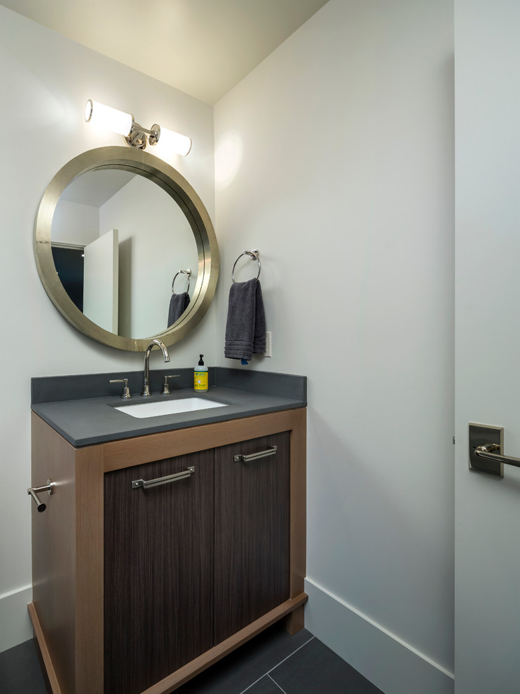 Inspiration for a large contemporary powder room in Salt Lake City with flat-panel cabinets, dark wood cabinets, black tile, ceramic tile, ceramic floors, an undermount sink and soapstone benchtops.
