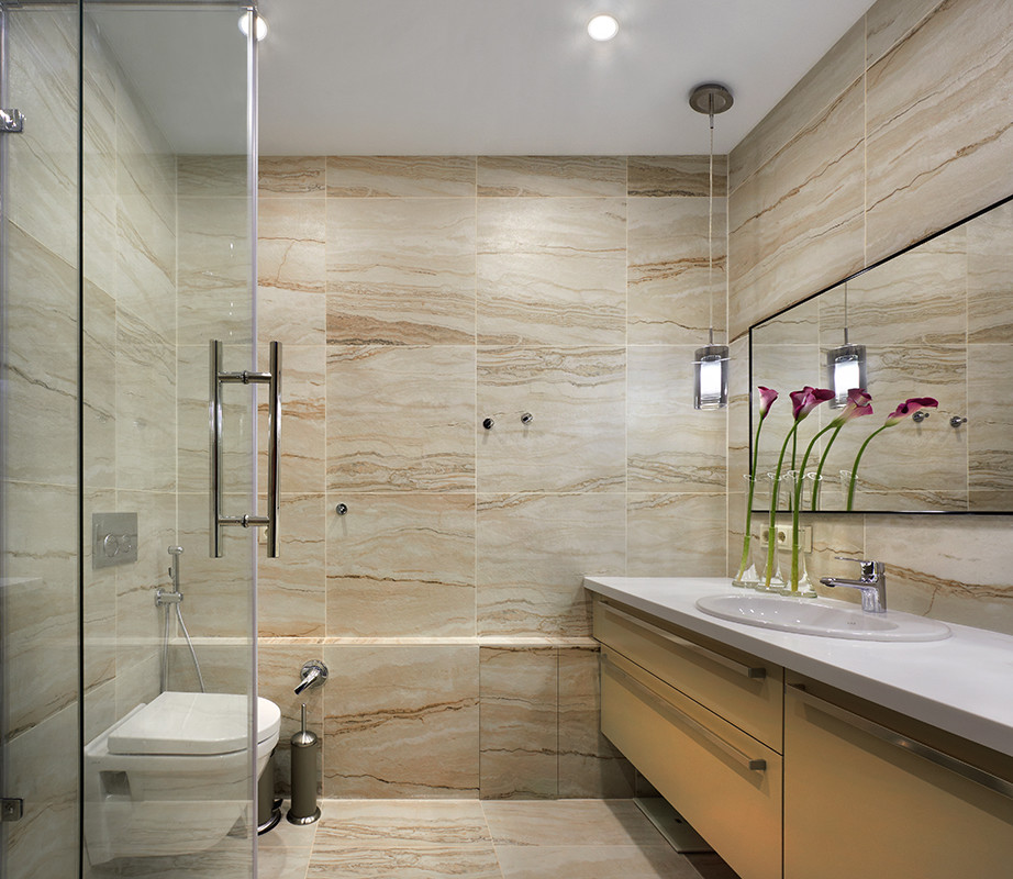 Design ideas for a contemporary 3/4 bathroom in Other with flat-panel cabinets, beige cabinets, a wall-mount toilet, beige tile, ceramic tile, beige walls, porcelain floors, an undermount sink, solid surface benchtops, beige floor and a hinged shower door.