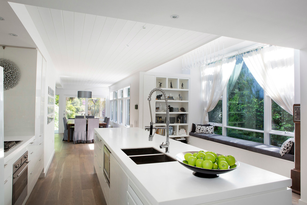 Design ideas for a contemporary galley open plan kitchen in Sydney with a double-bowl sink, flat-panel cabinets and white cabinets.