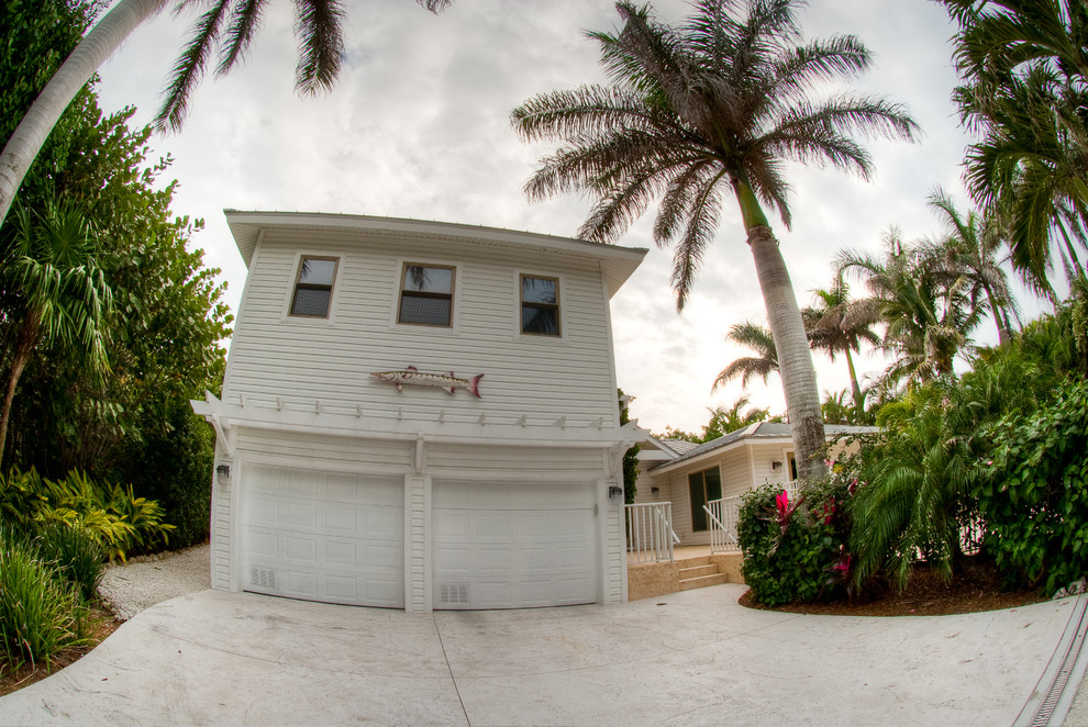Mid-sized beach style two-storey white house exterior in Miami.