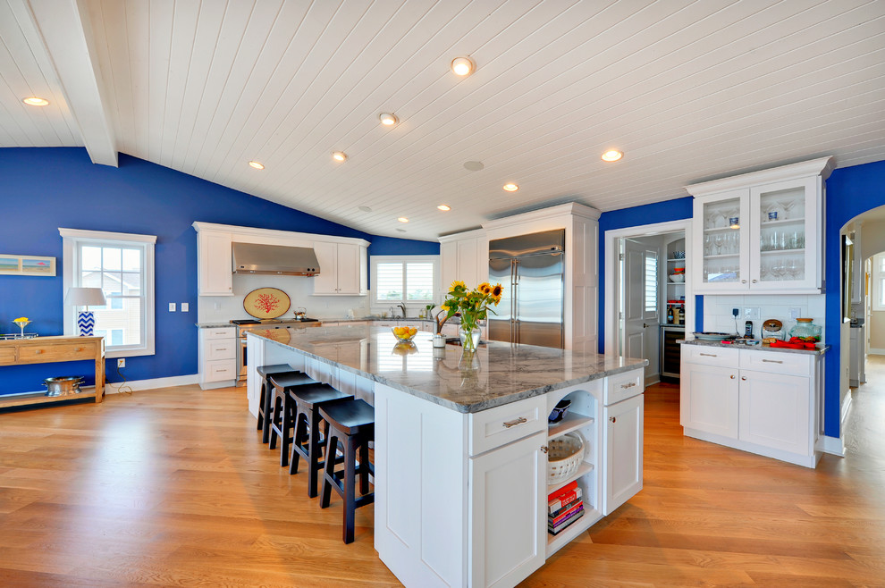 This is an example of a beach style kitchen in Philadelphia with shaker cabinets, white cabinets, white splashback and stainless steel appliances.