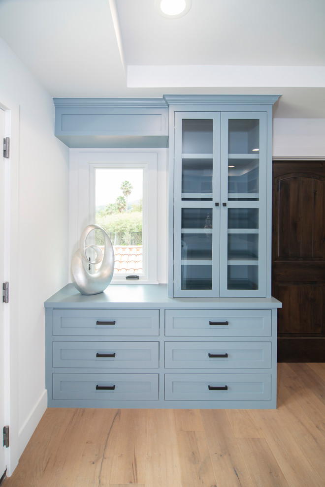Transitional women's walk-in wardrobe in San Francisco with beaded inset cabinets and blue cabinets.