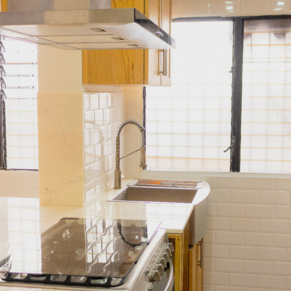 Inspiration for a rustic brown floor eat-in kitchen remodel with brown cabinets, quartzite countertops, white backsplash, subway tile backsplash, stainless steel appliances and white countertops