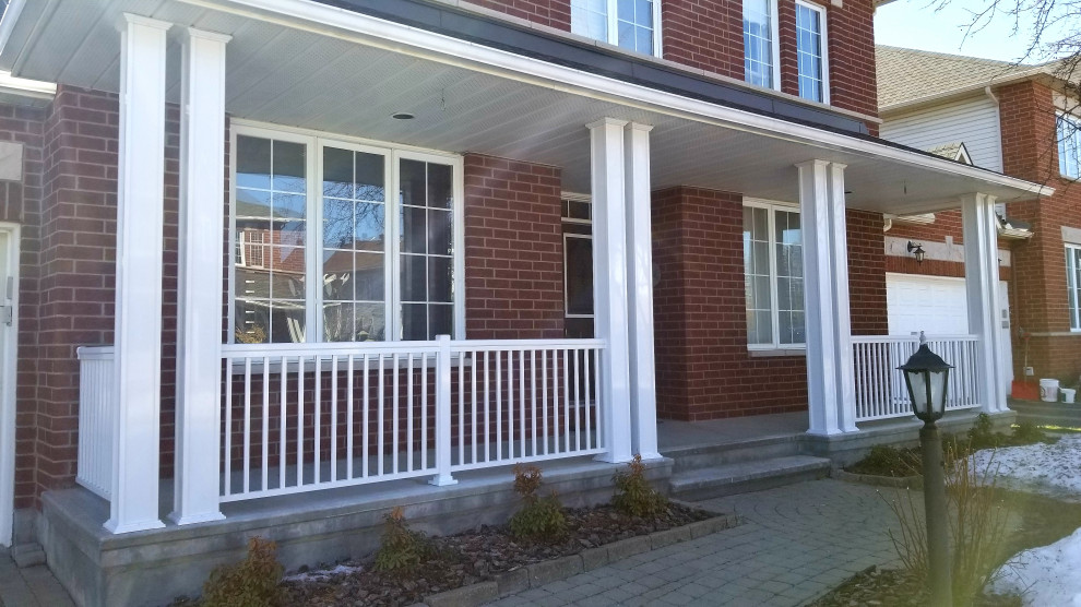 Photo of a mid-sized modern front yard verandah in Ottawa with with columns, a roof extension and metal railing.