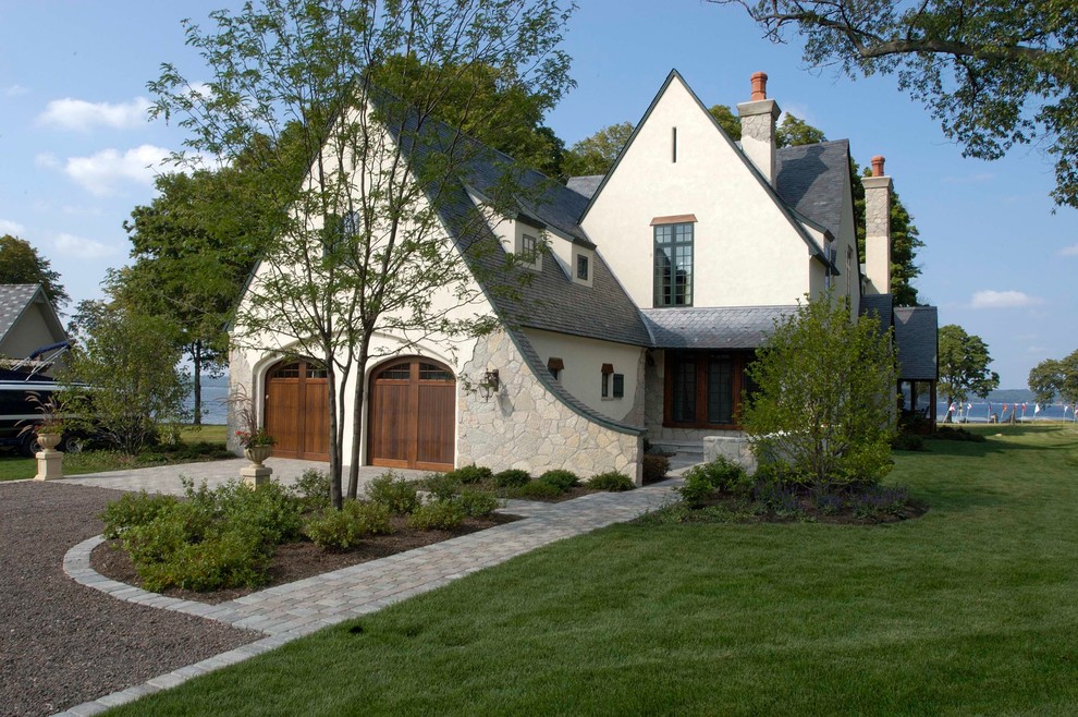 Expansive traditional three-storey stucco beige exterior in Chicago with a gable roof.