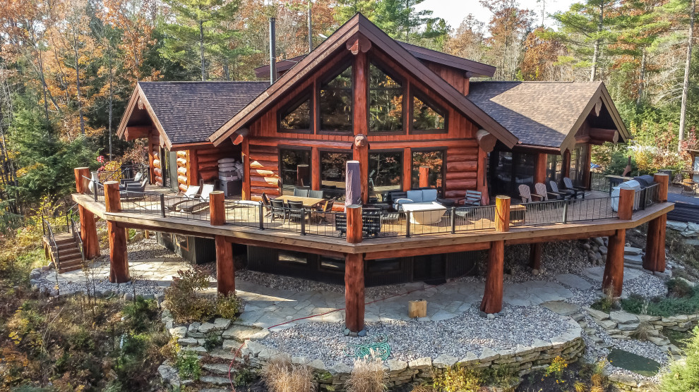 Mid-sized rustic brown three-story wood and board and batten gable roof idea with a shingle roof and a brown roof