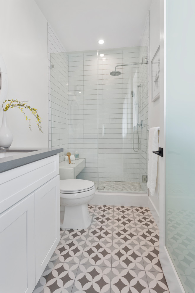 Transitional bathroom in Los Angeles with shaker cabinets, white cabinets, an alcove shower, white tile, blue walls, multi-coloured floor, a hinged shower door and grey benchtops.