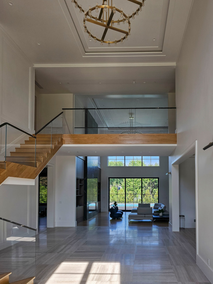 Photo of an expansive contemporary wood floating mixed railing staircase in DC Metro with wood risers and wainscoting.