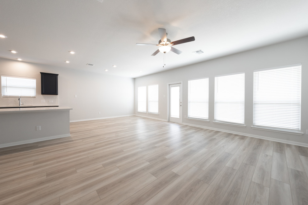 Aménagement d'un grand salon craftsman ouvert avec un mur gris, un sol en vinyl et un sol beige.