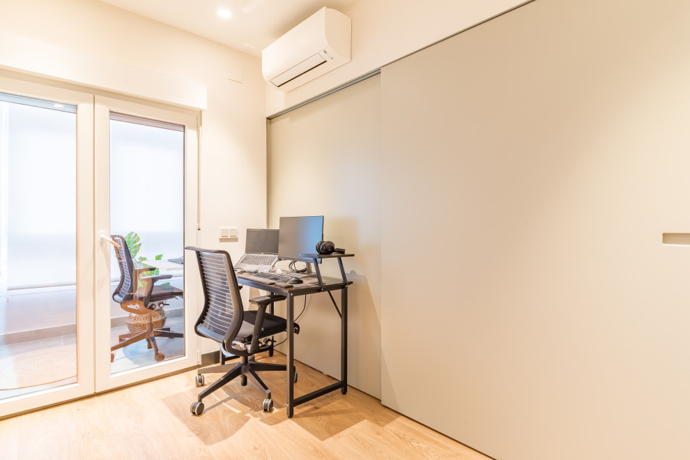 Foto de despacho escandinavo de tamaño medio con paredes grises, suelo de madera en tonos medios, escritorio independiente, suelo marrón, vigas vistas y panelado