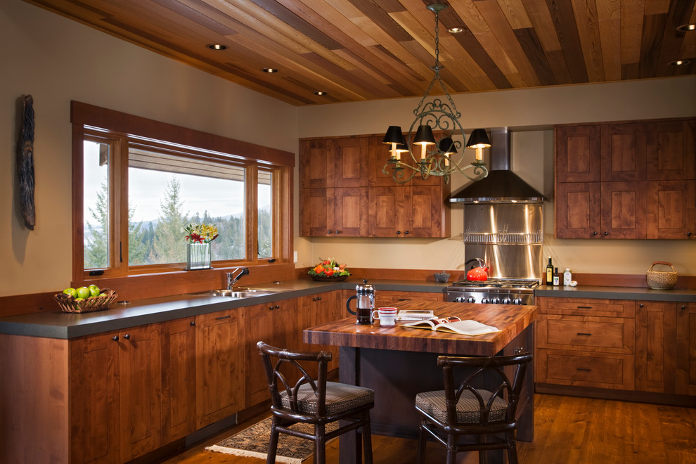 Inspiration for a mid-sized country u-shaped kitchen in Seattle with an undermount sink, medium wood cabinets, laminate benchtops, brown splashback, stainless steel appliances and with island.