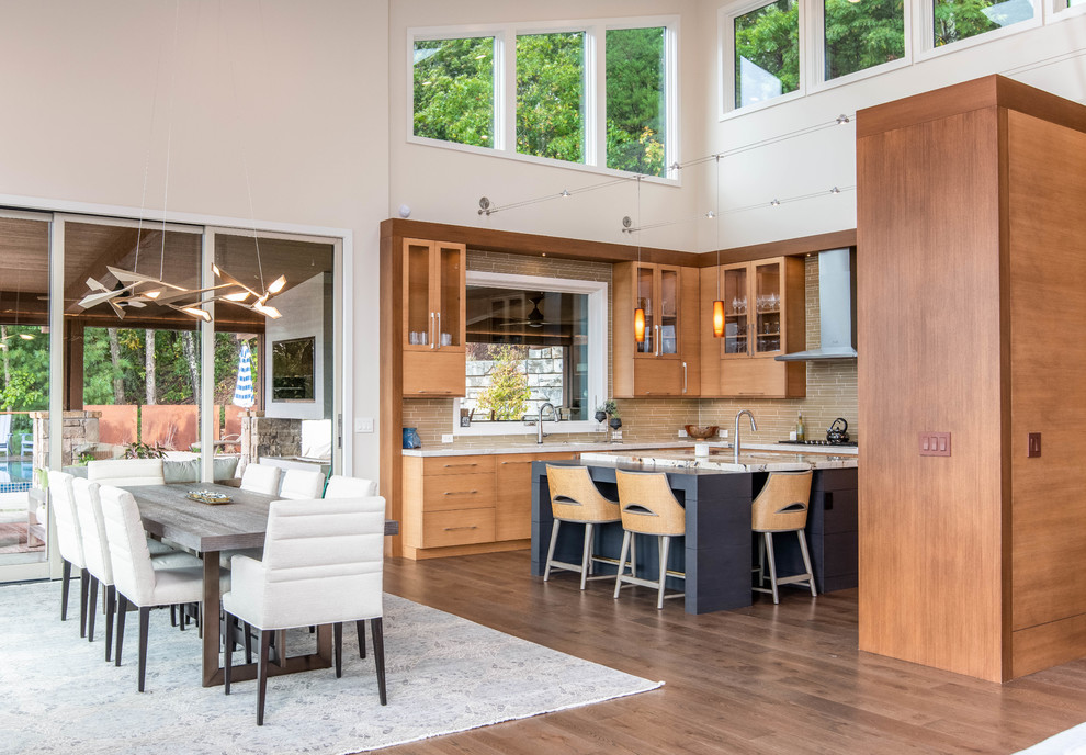 Inspiration for a mid-sized transitional u-shaped eat-in kitchen in Other with flat-panel cabinets, medium wood cabinets, quartzite benchtops, beige splashback, stainless steel appliances, medium hardwood floors, with island, brown floor and multi-coloured benchtop.