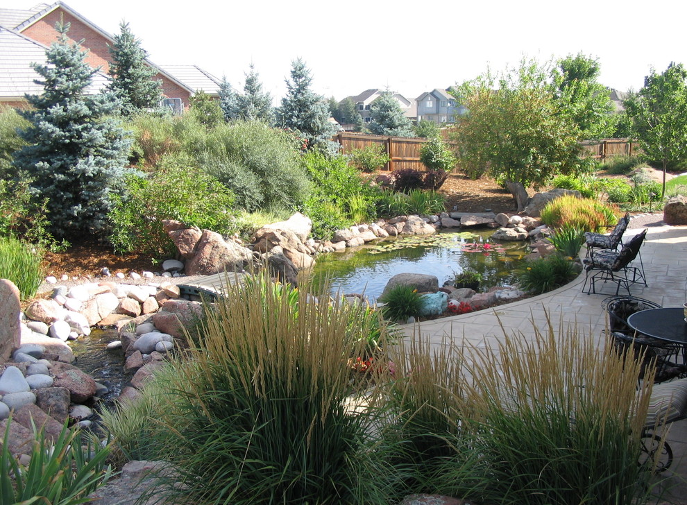 Design ideas for a large rustic front yard stone water fountain landscape in Denver.