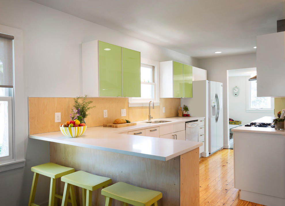 Transitional kitchen photo with white appliances and a peninsula