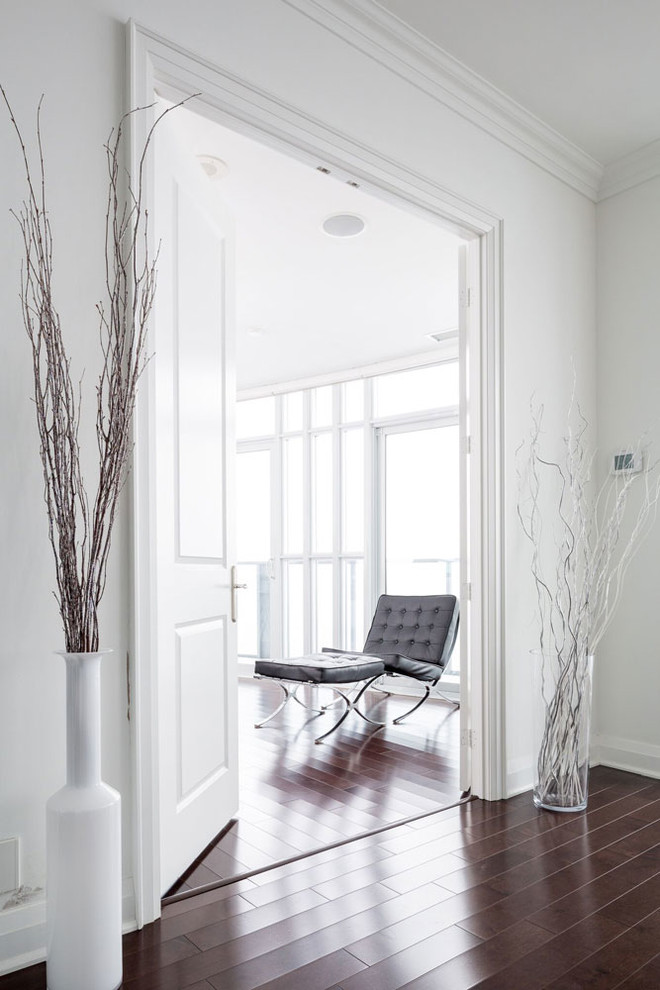This is an example of a mid-sized transitional hallway in Toronto with white walls and dark hardwood floors.