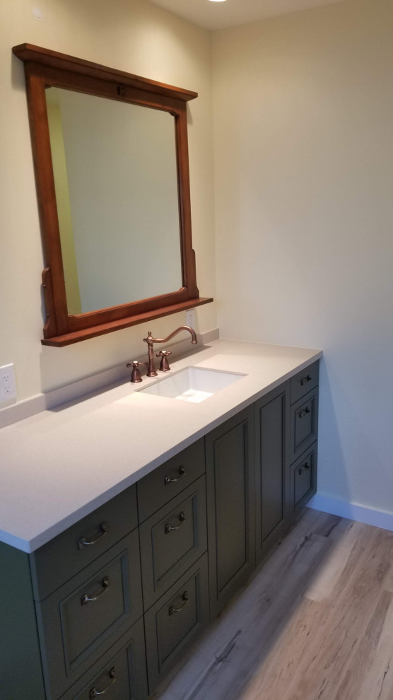 Photo of a small country bathroom in Los Angeles with recessed-panel cabinets, green cabinets, yellow walls, solid surface benchtops, beige benchtops, a single vanity and a built-in vanity.