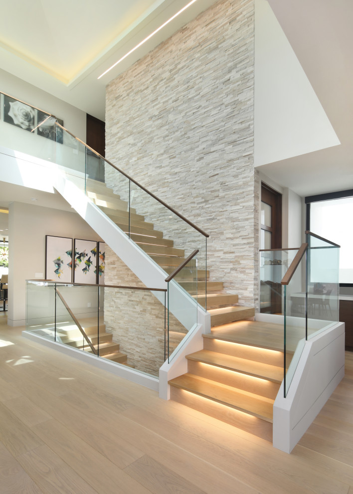 Foto de escalera suspendida moderna grande con escalones de madera y barandilla de vidrio