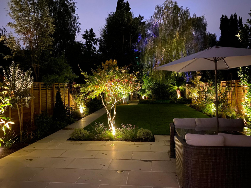 Immagine di un grande giardino formale design esposto in pieno sole dietro casa in estate con pavimentazioni in pietra naturale e recinzione in legno