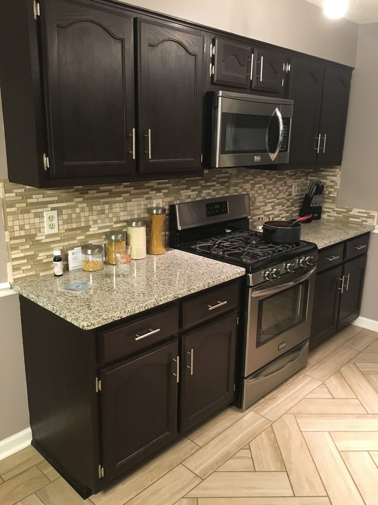 Eat-in kitchen - small transitional single-wall porcelain tile and beige floor eat-in kitchen idea with recessed-panel cabinets, dark wood cabinets, quartz countertops, multicolored backsplash, mosaic tile backsplash, stainless steel appliances and no island