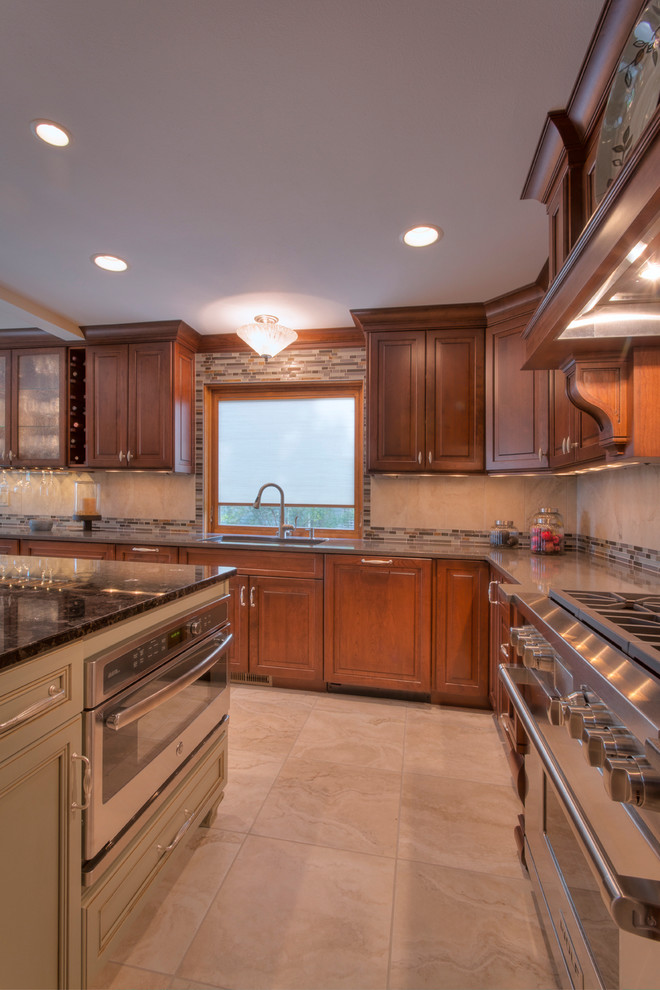 Inspiration for a large transitional l-shaped ceramic tile eat-in kitchen remodel with an undermount sink, raised-panel cabinets, medium tone wood cabinets, multicolored backsplash, mosaic tile backsplash, paneled appliances and an island