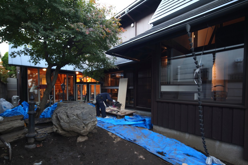 Photo of a medium sized and multi-coloured two floor house exterior in Tokyo with wood cladding, a half-hip roof, a metal roof, a grey roof and shiplap cladding.