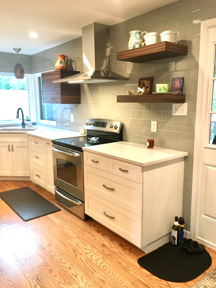 Inspiration for a small transitional u-shaped medium tone wood floor and brown floor enclosed kitchen remodel in Denver with a drop-in sink, shaker cabinets, white cabinets, quartz countertops, gray backsplash, subway tile backsplash, stainless steel appliances, a peninsula and white countertops