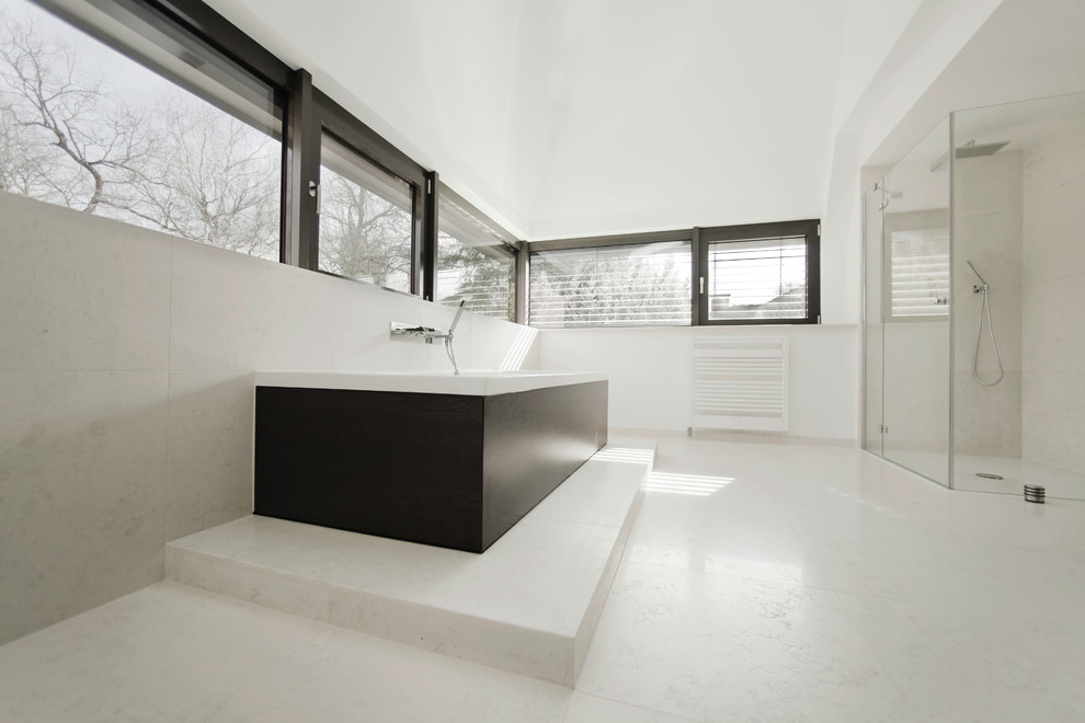 Design ideas for a large contemporary bathroom in Frankfurt with a drop-in tub, a corner shower, white walls, white tile, stone tile and limestone floors.