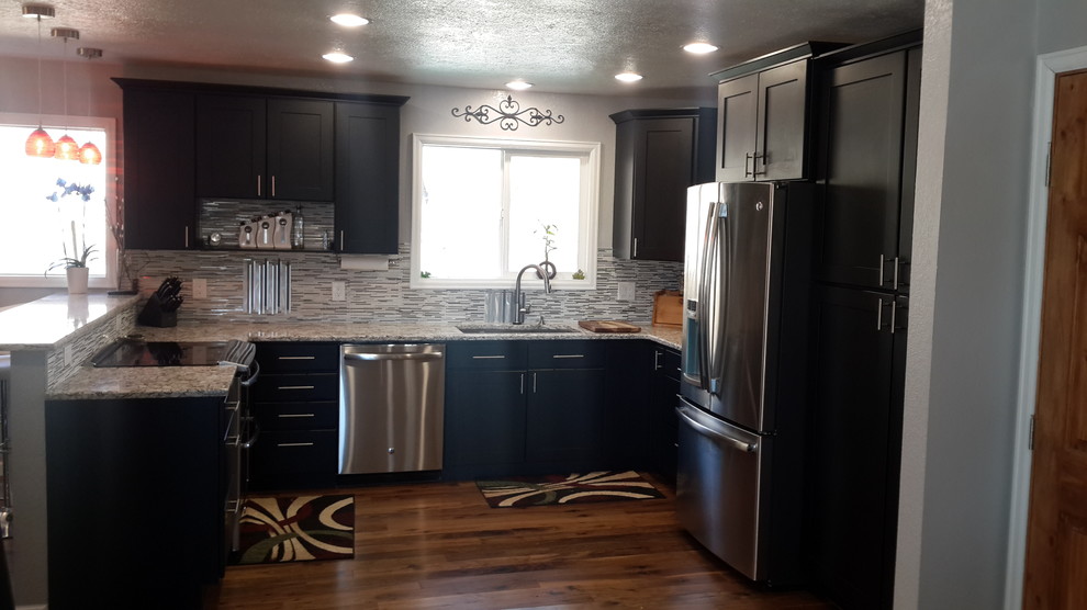 Inspiration for a mid-sized contemporary u-shaped eat-in kitchen in Denver with an undermount sink, shaker cabinets, black cabinets, multi-coloured splashback, glass tile splashback, stainless steel appliances, medium hardwood floors, no island and granite benchtops.