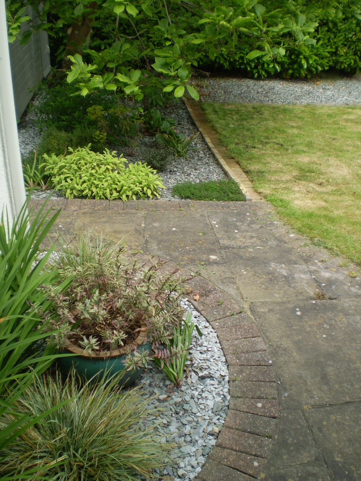 Small contemporary backyard partial sun garden in Sussex with a garden path and concrete pavers for spring.