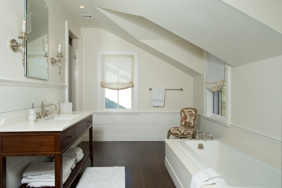 Inspiration for a mid-sized country 3/4 bathroom in New York with a drop-in tub, yellow walls, dark hardwood floors, a hinged shower door, flat-panel cabinets, dark wood cabinets, an undermount sink, solid surface benchtops and brown floor.