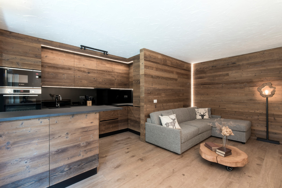 Esempio di una sala da pranzo aperta verso il soggiorno rustica di medie dimensioni con pareti bianche, pavimento in legno massello medio e pareti in legno