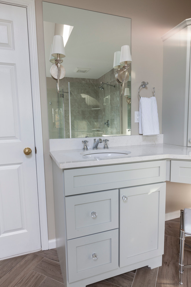 Freestanding bathtub - mid-sized transitional master gray tile and porcelain tile porcelain tile and gray floor freestanding bathtub idea in New York with flat-panel cabinets, gray cabinets, a two-piece toilet, gray walls, an undermount sink, quartz countertops and a hinged shower door