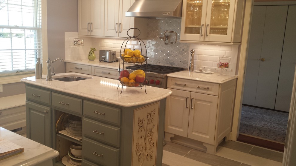 Inspiration for a small transitional u-shaped ceramic tile eat-in kitchen remodel with an undermount sink, raised-panel cabinets, white cabinets, marble countertops, white backsplash, subway tile backsplash, stainless steel appliances and an island