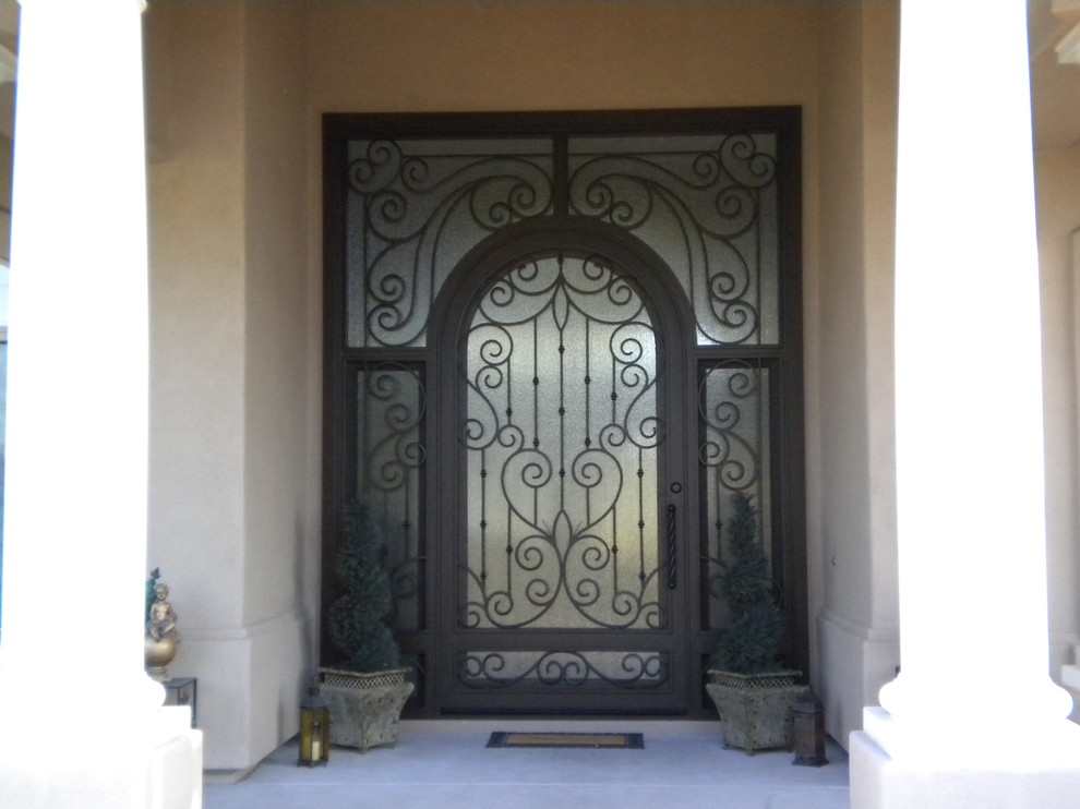 Inspiration for a large rustic concrete floor front door remodel in Phoenix with beige walls and a black front door
